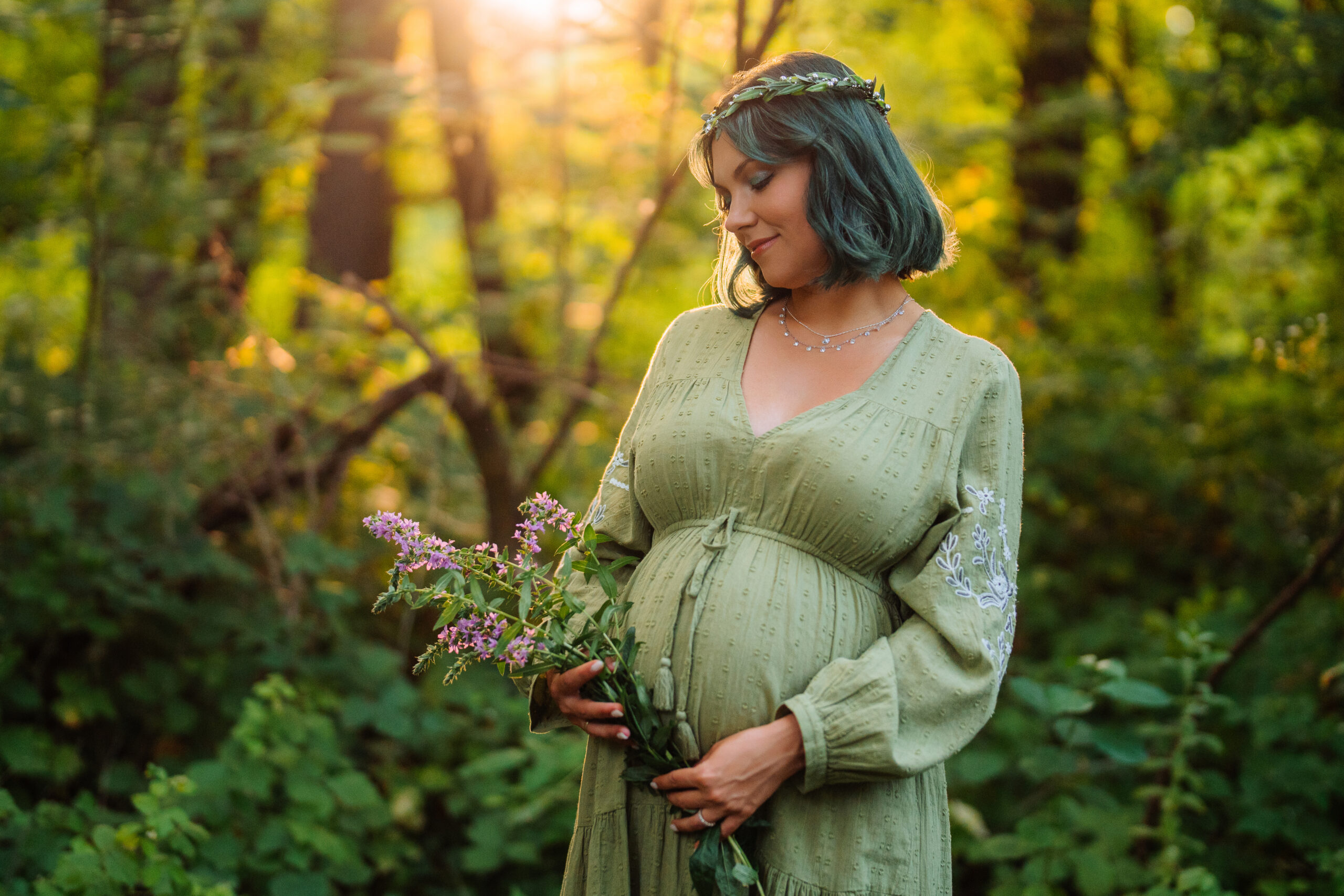 femme enceinte souriante tenant un bouquet de fleurs